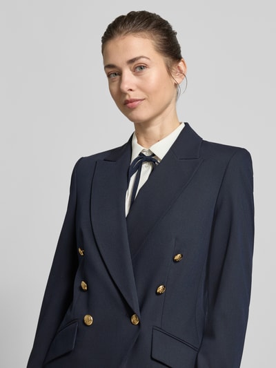 Frauenmodel trägt Slim Fit Blazer mit Viskose-Anteil von Christian Berg Woman Selection in Dunkelblau, goldene Zierknöpfe, Reverskragen, Elastischer-Material-Mix, Pattentaschen, Nahaufnahme Oberkörper.