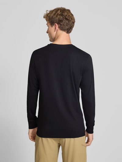 Männermodel trägt zwart shirt met lange mouwen van katoenmix Model 'EVOLUTION' van The North Face, los model, labelstitching, ruglengte maat M 70 cm, Ganzkörperansicht Rückansicht.