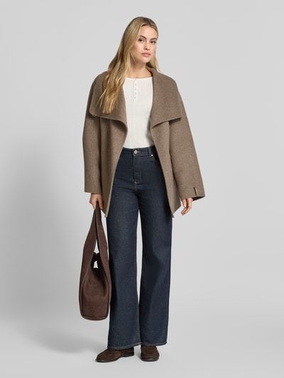 Frauenmodel trägt Kurzblazer aus Woll-Mix mit Bindegürtel von COMMA in Beige, strukturierte Oberfläche, kombiniert mit blauer Jeans, Ganzkörperansicht von vorne. Regular Fit, breiter Umlegekragen, Eingrifftaschen, Rückenlänge 76 cm, Schulterbreite 48 cm, Brustweite 57 cm, Ärmellänge 58 cm, Woll-Mix mit Viskose-Anteil.