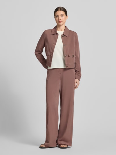 Frauenmodel trägt Blazer mit Pattentaschen und Knopfleiste von Christian Berg Woman Selection im Viskose-Mix, Gerader-Schnitt, warme Braun- und Cremetöne, glatte Textur, Kentkragen, elastische Ärmelabschlüsse, Ganzkörperansicht von vorne.