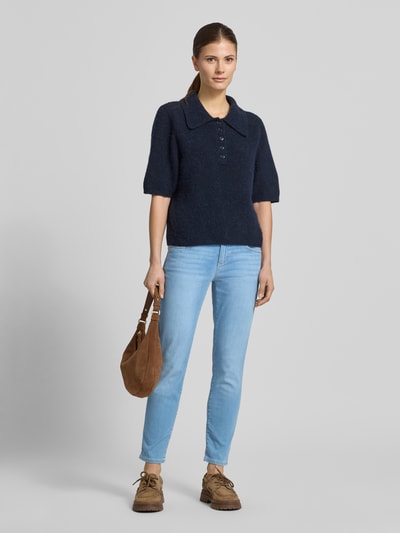 Kobiece modelka nosi Slim Fit Jeans mit Eingrifftaschen Modell 'SHAKIRA' od Brax, mieszanka bawełny i lyocellu, krój slim fit, wpuszczane kieszenie, szerokość w rozmiarze 36: 37 cm, długość wewnętrzna nogawki 70 cm, jasnoniebieski odcień, gładka faktura, widok całej sylwetki z przodu.