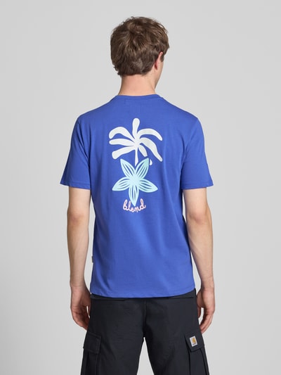 Männermodel trägt Herren T-Shirt mit Motiv-Print Modell 'SUN PALMS' von Blend, Reine Baumwolle, Regular-Fit, Rundhalsausschnitt, Rückenlänge 73 cm, kräftiges Blau, weiße und pastellfarbene Palmen-Prints, glatte Textur, Ganzkörperansicht Rückansicht.