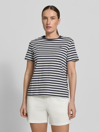 Frauenmodel trägt T-Shirt mit Rundhalsausschnitt und Label-Stitching von Gant aus Reine Baumwolle, Regular-Fit, Rückenlänge 56 cm, Ganzkörperansicht von vorne.