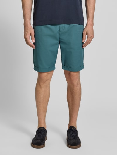 Männermodel trägt Chino-Shorts mit Gesäßleistentaschen von Lerros in Türkis, Baumwoll-Mix mit Stretch-Anteil, Straight Fit, Ganzkörperansicht von vorne. Bundweite 42 cm, Innenbeinlänge 24 cm, mit Elastischer Bund, Knopf-Reißverschluss, Französische Eingrifftaschen.