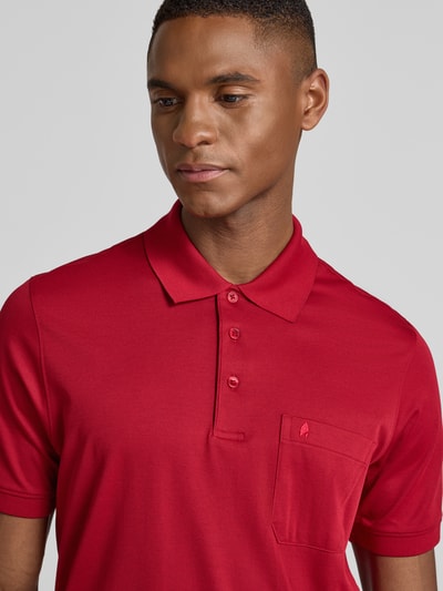 Męskimodel nosi Regular Fit Koszulka polo z brustaszą od RAGMAN z bawełny, wyhaftowane logo, kolor czerwony, nahaufnahme oberkörper.