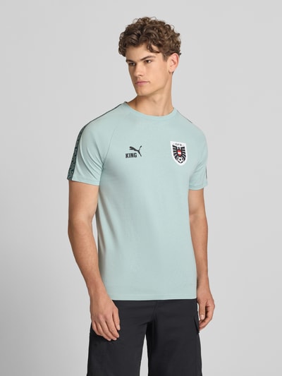 Männermodel trägt Herren T-Shirt mit Rundhalsausschnitt Modell 'ÖFB KING' von PUMA PERFORMANCE, Reine Baumwolle, Regular-Fit, Hellblau, Ganzkörperansicht von vorne. Rückenlänge bei Größe M: 69 cm.