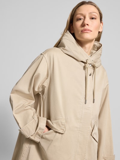 Frauenmodel trägt Regular Fit Parka aus reiner Baumwolle von Marc O'Polo in Beige mit Kapuze, Tunnelzug, Klappentaschen, Nahaufnahme Oberkörper.