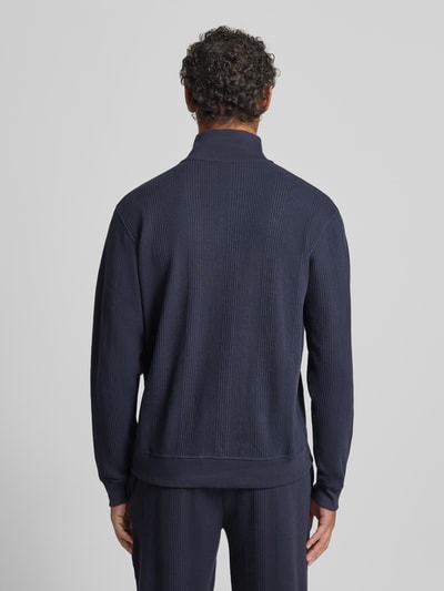 Männermodel trägt Regular Fit Troyer aus Baumwoll-Mix Modell 'STRUCTURE' von BOSS in Dunkelblau, Struktur-Muster, Unifarben, Label-Applikation, Troyer-Kragen, Reißverschluss, Langarm, gerippte Abschlüsse, Ganzkörperansicht Rückansicht.