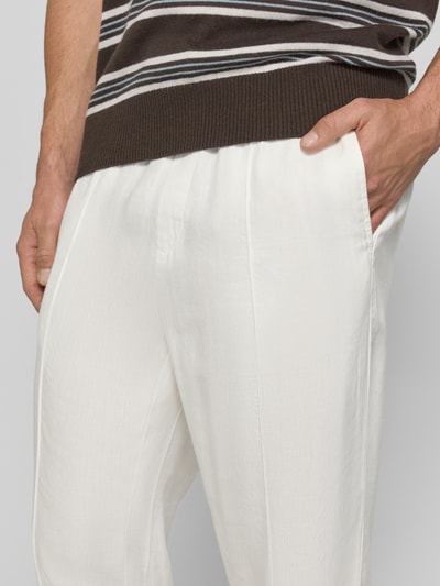 Männermodel trägt Straight Fit Schmale Hose aus Leinen-Lyocell-Mix Modell 'CINO' von HUGO in Weiß mit feiner Flammgarn-Textur, Nahaufnahme Oberschenkel.