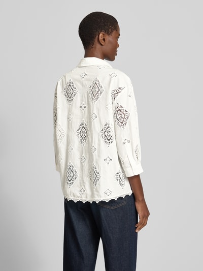 Frauenmodel trägt Regular-Fit Damen Bluse mit Häkelspitze Modell 'MURIEL' von Bash in Weiß, Hemdblusenkragen, verdeckte Knopfleiste, 3/4-Arm, Rückenlänge 65 cm, Ärmellänge 40 cm, lockere Passform, Muster aus Lochspitze, ganzflächig verziert, Ganzkörperansicht Rückansicht.