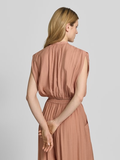 Frauenmodel trägt Cropped Blusentop mit Knopfverschluss von Style Icon Collection, weich fallender Stoff in Rosa, elastischer Bund, Rückenlänge 42 cm, Ganzkörperansicht Rückansicht.