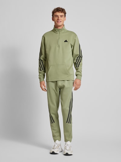 ADIDAS SPORTSWEAR Spodnie dresowe o kroju tapered fit z charakterystycznymi dla marki paskami Oliwkowy 1