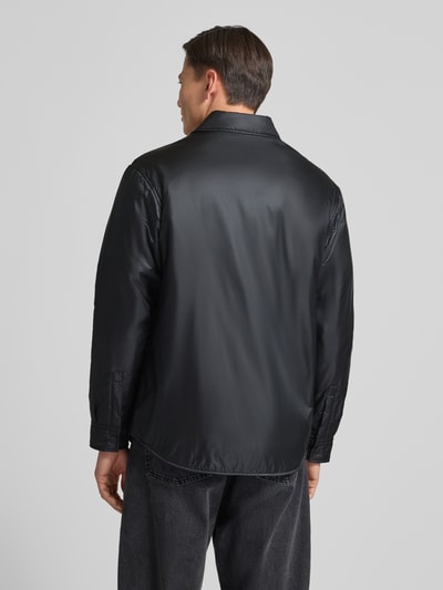 Männermodel trägt Oversized Kurtka z wykładanym kołnierzem Model 'EVINUZ' od HUGO, jednokolorowy, wpuszczane kieszenie, wyhaftowane logo, długi rękaw, mankiety, zapięcie na guziki, ganzkörperansicht rückansicht.