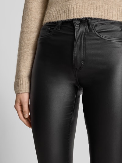 Kobiece model prezentuje Skinny Fit Jeansy z mieszanki wiskozy Model 'ROYAL' od ONLY, czarne, powlekane, 5 kieszeni, widok z przodu, zbliżenie na górną część.