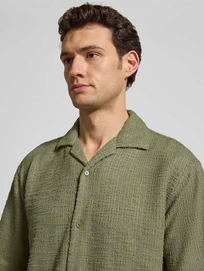 Männermodel trägt Regular Fit Freizeithemd mit Strukturmuster von MCNEAL in Olivgrün, Elastischer-Material-Mix, Nahaufnahme Oberkörper.