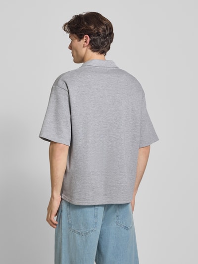 Männermodel trägt Regular Fit Poloshirt mit Logo Modell 'Eddie' von Redefined Rebel aus Baumwoll-Mix in Grau, Rückenlänge bei Größe M 73 cm, Ganzkörperansicht Rückansicht.
