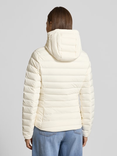 Kobiece modelka nosi Slim Fit Daunenjacke mit abnehmbaren Kapuze von Tommy Hilfiger, jednokolorowa, hydrorofobowa, długi rękaw, kieszenie na zamek, zaokrąglone wykończenie, Ganzkörperansicht Rückansicht.