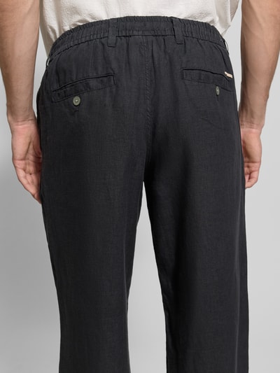 Männermodel trägt Leinenhose mit Eingrifftaschen Modell 'KARL LAWRENCE' von Jack & Jones Premium in Dunkelgrau, strukturierte Oberfläche, Gesäßleistentaschen, Reines Leinen, Straight Fit, Innenbeinlänge 75 cm, Bundweite 42 cm, elastischer Bund, Knopf- und Reißverschluss, Ganzkörperansicht Rückansicht.