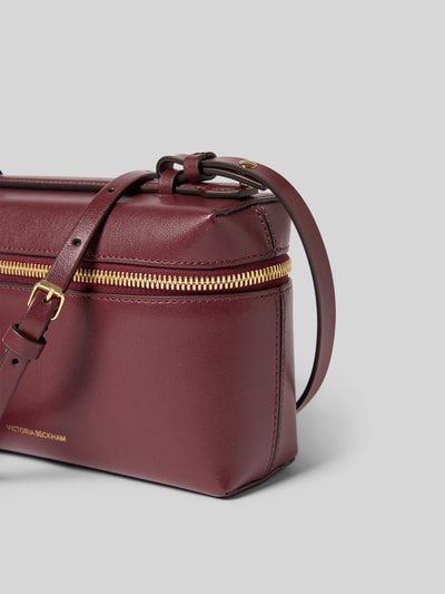Produktfoto, Crossbody Bag aus echtem Leder von Victoria Beckham in Bordeaux mit Rundum-Reißverschluss, verstellbarem Schulterriemen, Dornschließe, Label-Print in metallic, Hauptfach, Maße: 21 cm Breite, 13 cm Länge, 7 cm Tiefe.