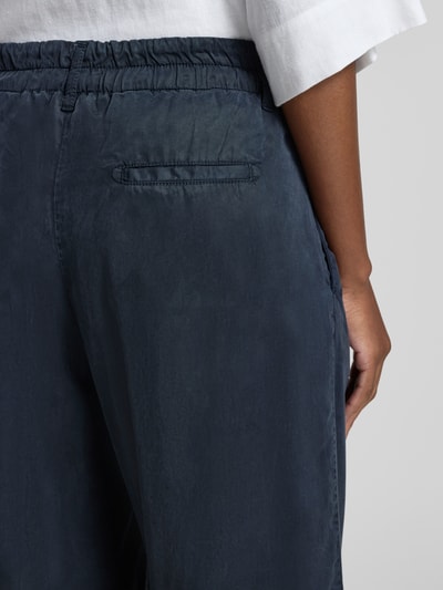 Frauenmodel trägt Regular Fit Culotte aus Lyocell Modell 'MAINE S' von Brax in Dunkelblau, seitliche Eingrifftaschen, Nahaufnahme Rückansicht.
