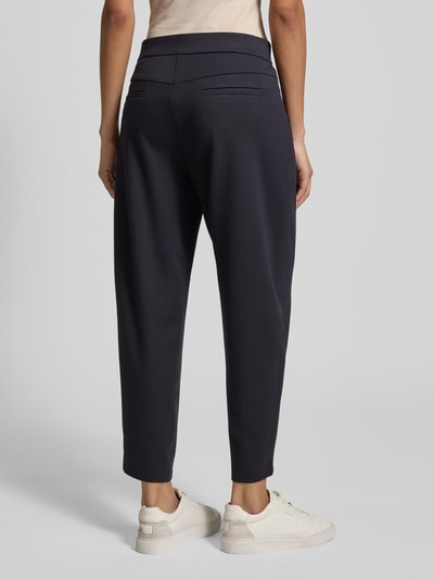 Frauenmodel trägt Stoffhose in verkürzter Passform Modell 'ORCHID' von Cambio, Viskose-Mix, Elastikbund, Gesäßtaschen, Ganzkörperansicht Rückansicht.