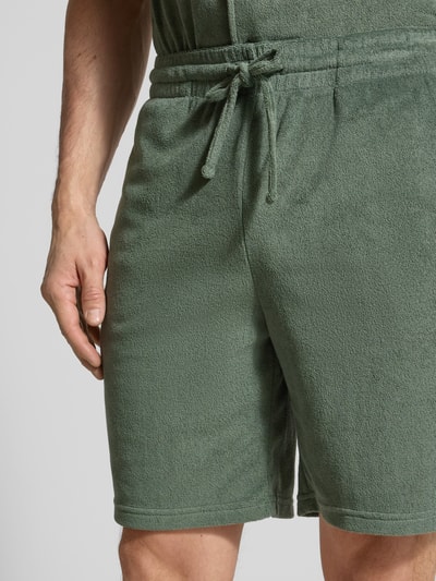 Männermodel trägt Shorts mit elastischem Bund von MCNEAL aus grünem Baumwoll-Mix, Regular-Fit, Tunnelzug, Nahaufnahme Oberkörper.