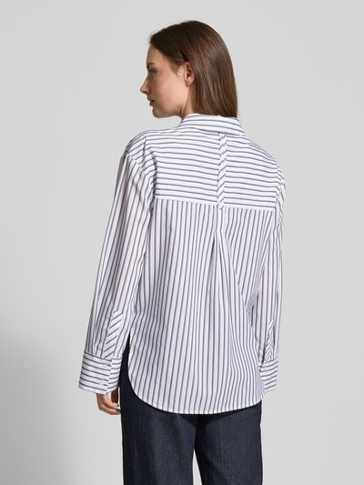 Vrouwenmodel draagt Relaxed Fit Hemdbluse aus Lyocell-Mix Modell 'Fapo' van OPUS in wit met zwarte strepen, lange mouwen, rugpand plooidetail, sportmanchetten, doorlopende knoopsluiting, lyocellmix, ruglengte bij maat 36: 68 cm, mouwlengte bij maat 36: 57 cm, volledige rugaanzicht.