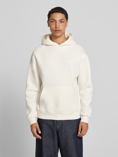 Männermodel trägt Regular Fit Hoodie mit Känguru-Tasche von REVIEW aus Baumwoll-Mix in Creme, Kapuze, Ganzkörperansicht von vorne. Rückenlänge bei Größe M: 70 cm, Ärmellänge bei Größe M: 62 cm.
