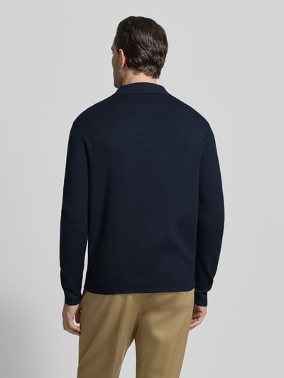 Männermodel trägt Relaxed Fit Pullover aus Viskose-Mix Modell 'TELLER' von SELECTED HOMME in Dunkelblau, Feinstrick, Ganzkörperansicht Rückansicht.