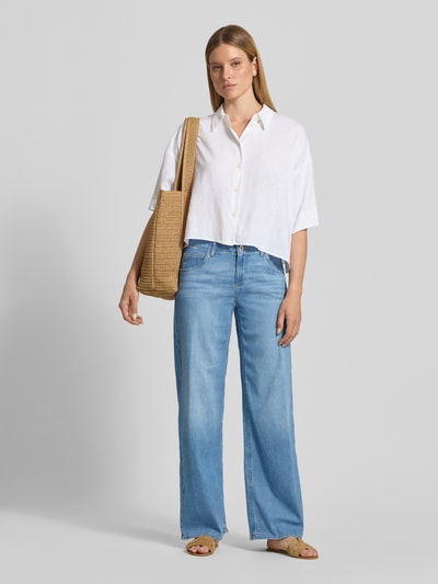Frauenmodel trägt Wide Leg Jeans aus Baumwoll-Mix Modell 'STYLE.MAINE' von Brax, Denim-Optik, Loose-Fit, Label-Applikation aus Metall, Gürtelschlaufen, Knopf- und Reißverschluss, 5-Pocket-Design, hellblaues Material, Ganzkörperansicht von vorne.