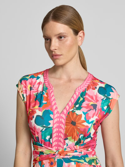 Modelka kobieca nosi Jumpsuit im Allover-Look mit Knotendetail od ROBE LÉGÈRE, kolorowy wzór, mieszanka materiałów z dodatkiem stretchu, krój regular fit, dekolt V, taśma z węzłem w talii, szerokość w rozmiarze 36: 52 cm, długość tyłu: 139 cm, długość całkowita: 139 cm, długość nogawki po wewnętrznej stronie: 68 cm, zbliżenie na górną część ciała.