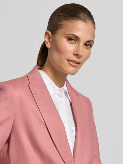 Vrouwenmodel draagt Blazer mit Reverskragen und Pattentaschen van Jake*s Collection in lichtroze, gladde textuur, getailleerd model, knoopsluiting, klepzakken, ruglengte maat 38: 65 cm, borstwijdte: 46 cm, mouwlengte: 62 cm, Nahaufnahme bovenlichaam.