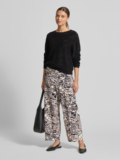 Frauenmodel trägt Relaxed Fit Stoffhose mit Allover-Print Modell 'Sally' von Raffaello Rossi, Damen Stoffhose im Elastischer-Material-Mix mit elastischem Bund und Logo-Detail, helle und dunkle Kontraste, Ganzkörperansicht von vorne.