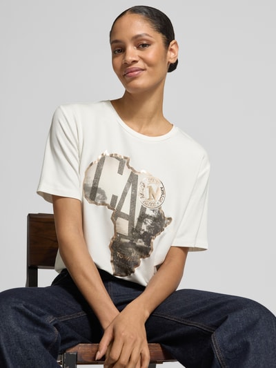 Vrouwenmodel draagt T-Shirt mit Motiv-Print van monari, regular fit, viscose-mix met modal, ronde hals, siersteentjes, wit-zwart motief, bovenlichaam close-up