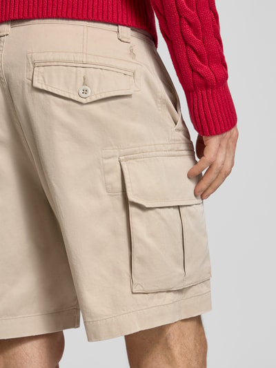 Männermodel trägt Relaxed Fit Cargoshorts aus reiner Baumwolle von Polo Ralph Lauren in Beige mit Webstruktur und Cargotaschen, Ganzkörperansicht Rückansicht.