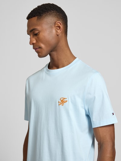 Männermodel trägt Regular Fit T-Shirt aus reiner Baumwolle von Tommy Hilfiger in Optik: Unifarben mit Logo-Stitching, Rundhals, Kurzarm, Nahaufnahme Oberkörper.