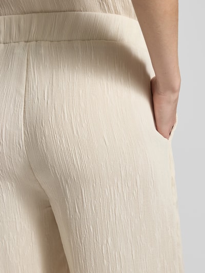 Frauenmodel trägt Wide Fit Stoffhose aus Viskose-Mix Modell 'Mucia' von OPUS PANTS, Strukturmuster, elastischer Bund, Nahaufnahme Oberkörper.