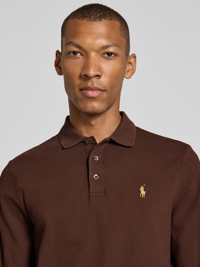 Männermodel trägt dunkelbraunen Slim Fit Pullover aus Baumwoll-Mix von Polo Ralph Lauren, dezente Struktur, Nahaufnahme Oberkörper.
