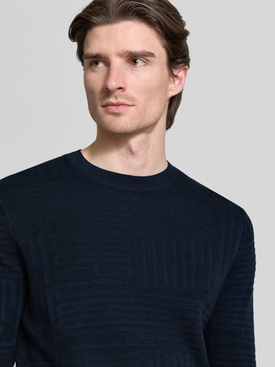 Mężczyzna nosi Strickpullover mit gerippten Abschlüssen Modell 'Raikon' von JOOP! Collection, czarny, krój regular fit, czysta bawełna, zbliżenie na górną część ciała.