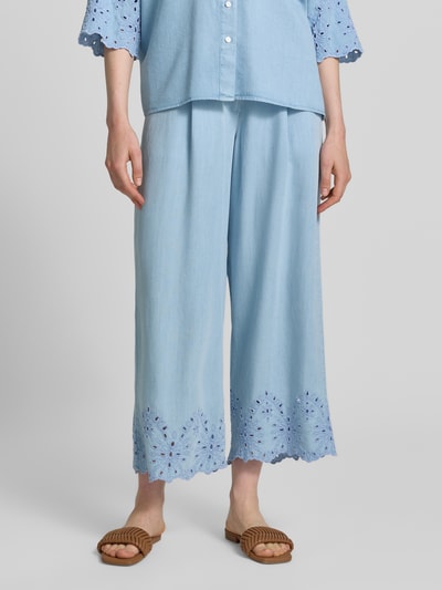 Frauenmodel trägt Hose mit Lochstickerei und französischen Eingrifftaschen von Smith and Soul in Hellblau aus Lyocell, Wide-Leg-Fit, elastischer Bund mit Knopf-Reißverschluss, feine Textur, Ganzkörperansicht von vorne.