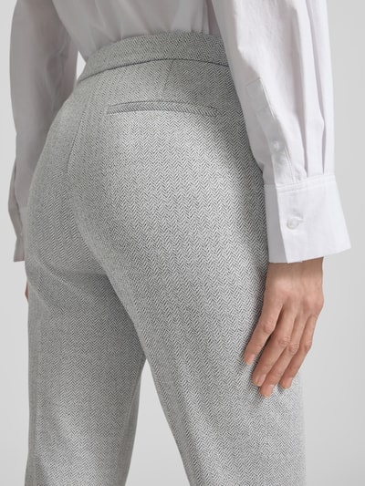 Frauenmodel trägt Regular Fit Anzughose mit Baumwoll-Anteil Modell 'TIMASA1' von BOSS mit Fischgrätmuster, Detailaufnahme Rückansicht.