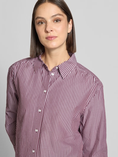 Frauenmodel trägt Loose Fit Hemdbluse aus Baumwoll-Lyocell-Mix von Tom Tailor, feine weiße Streifen auf weinrotem Grund, Nahaufnahme Oberkörper, Damen Hemdbluse von Tom Tailor