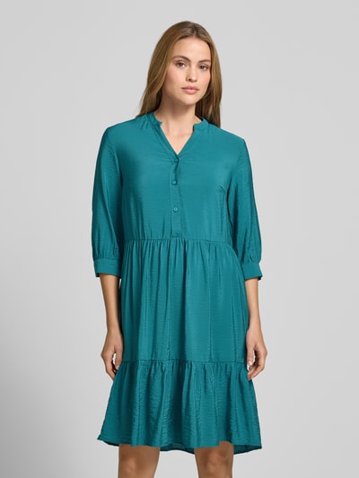 Frauenmodel trägt Relaxed Fit Midikleid aus Viskose-Mix mit Tunika-Ausschnitt von Christian Berg Woman, Knopfleiste, Halbarm, Türkiston, Ganzkörperansicht von vorne, Rückenlänge bei Größe 36: 106 cm, Brustweite bei Größe 36: 45 cm, Ärmellänge bei Größe 36: 44 cm, strukturierte Oberfläche.