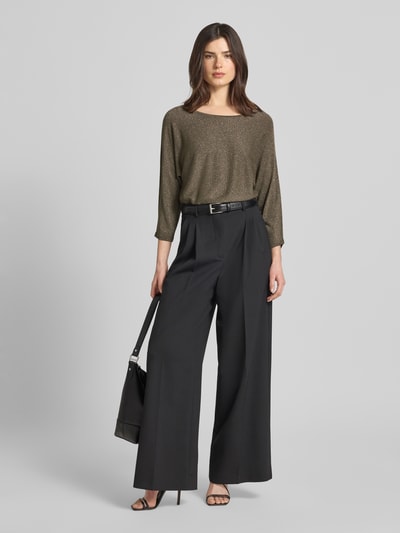 Modelka nosi Strickshirt aus Viskose-Mix mit 3/4-Arm od comma, mieszanka wiskozy, krój regular fit, efekt błyszczący, okrągły dekolt, rękaw o dł. 3/4, długość tyłu w rozmiarze 36: 61 cm, długość rękawów w rozmiarze 36: 50 cm, widok całej sylwetki z przodu.