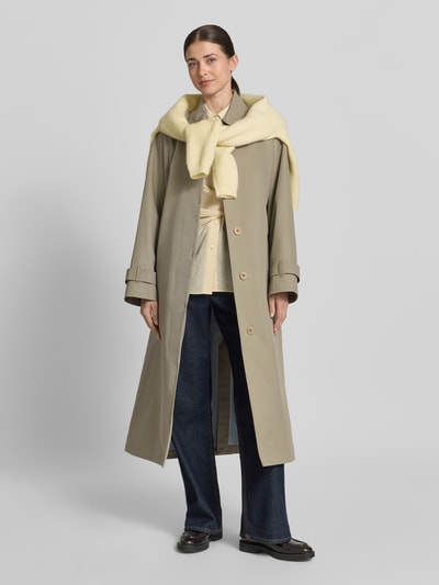 Frauenmodel trägt Regular Fit Mantel mit Umlegekragen Modell 'Hanna' von G-LAB aus Baumwoll-Mix, Eingrifftaschen, Stoffgürtel, Ganzkörperansicht von vorne.