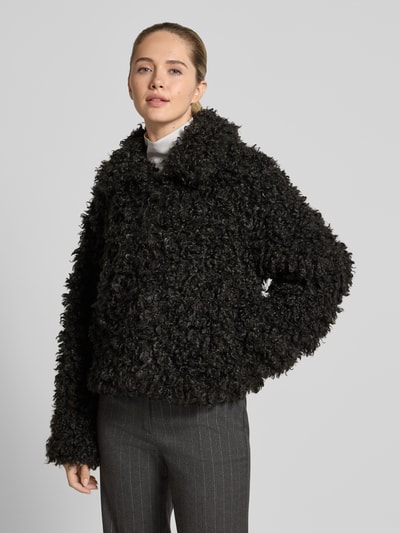 Frauenmodel trägt Felljacke in cropped-Fit - curated by Isabelle Hartmann von Style Icon Collection in Schwarz, Kunstfell mit lockiger Textur, Reißverschluss, Regular Fit, Ganzkörperansicht von vorne.