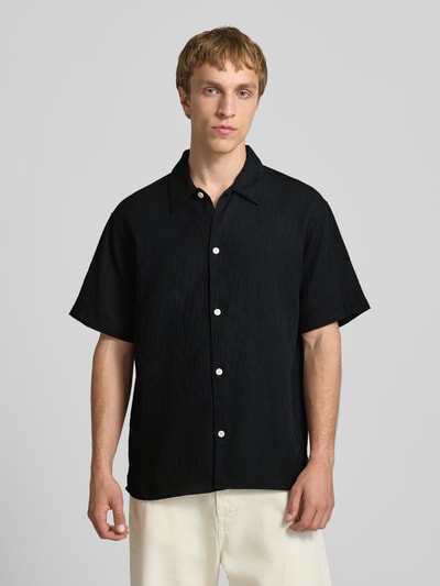 Männermodel trägt Regular fit Freizeithemd mit Strukturmuster Modell 'MONTAUK' van Jack & Jones, zwarte kleur, katoen, kentkraag, knoopsluiting, Ganzkörperansicht von vorne.
