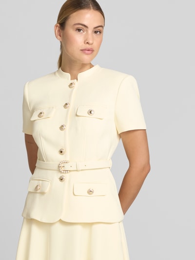 Frauenmodel trägt Maxikleid mit Stehkragen von Self-Portrait in Creme, taillierte Passform, Pattentaschen, abnehmbarer Tailliengürtel, Kurzärmelig, Nahaufnahme Oberkörper.
