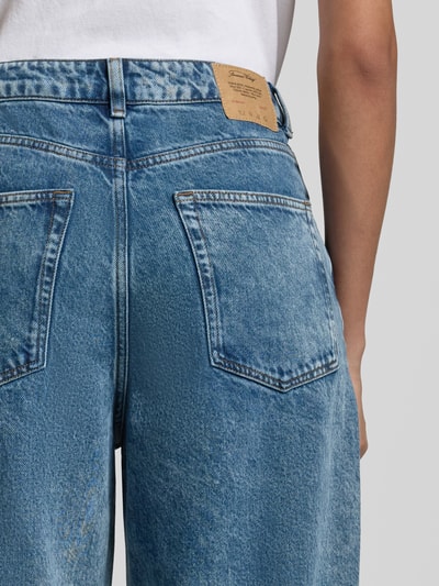 Männermodel trägt Straight Fit Jeans im 5-Pocket-Design Modell 'Joybird' von American Vintage, niebieski denim, widoczne tylne kieszenie, detal z tyłu.