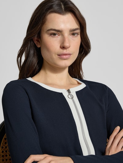 Kobiece modelka nosi Slim Fit Jacke mit Viskose-Anteil in Strick-Optik von Betty Barclay, elastyczna mieszanka materiałów, okrągły dekolt, imitacja dzianiny, detal z zamkiem błyskawicznym dwustronnym i kieszenie z patką, długość tyłu w rozmiarze 36: 54 cm, zbliżenie na górną część ciała.